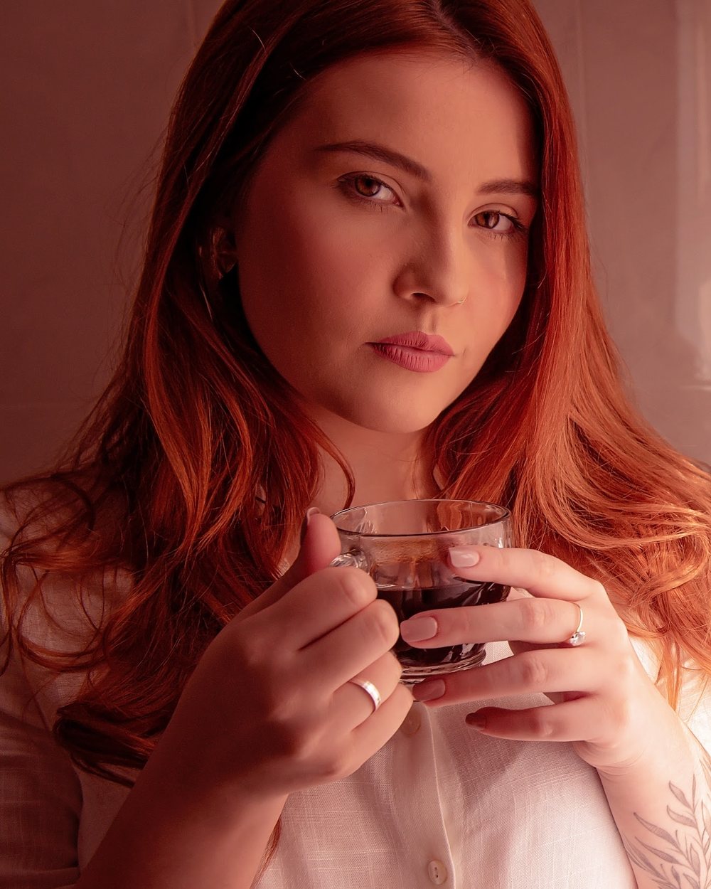 Duda segurando um copo de café, em um fundo marrom
